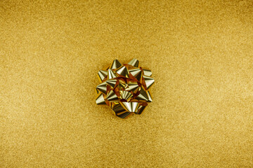 Fototapeta na wymiar Gold gift bow on a gold background. Holidays.