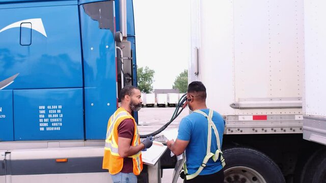 Trucker And Warehouse Worker Checking Container Semi Truck