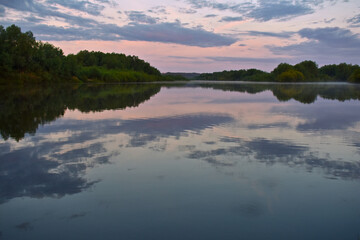 Naklejka premium colorful and misty dawn over a small river
