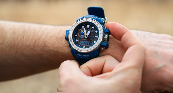 Smakhtino / Russia - April 2020: Casio G-shock GWN-1000 watches blue color from the electronics manufacturer company Casio. Men's wrist watch on the male hand of a traveler who is on a trip. banner