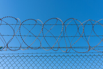 meshed rath fence and barb wire