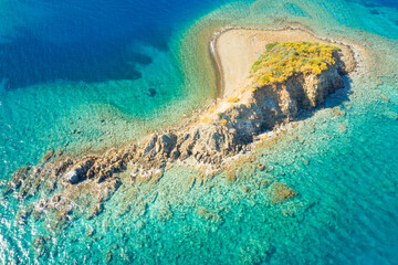 wild rock island in emerald lagoon with clear water