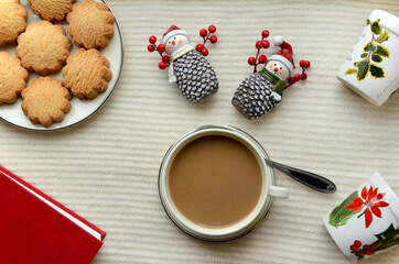 winter still life christmas cookies and cup of coffee a book and New Year's souvenirs snowman figure
