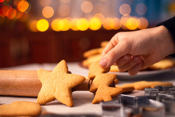 Cookies in star and christmas tree shapes on the table near rolling pin and baking accessories....