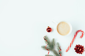 Obraz na płótnie Canvas Christmas cup of coffee with candy cane next to fir branch