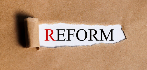 REFORM, text on white paper on torn paper background