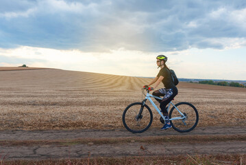 Fototapeta premium girl on a bicycle travels through the autumn field