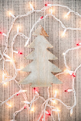 Wooden Christmas tree decorative piece surrounded by white and red Christmas lights. Natural light.  - 388863383