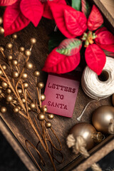 Wooden box filled with Christmas decorations such as an ornament saying Letters to Santa.  - 388863732