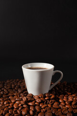Espresso coffee cup with coffee beans on black background.