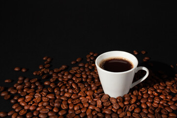 Espresso coffee cup with coffee beans on black background.