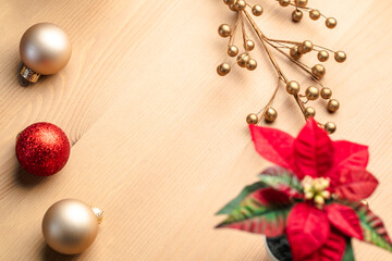 A collection of Christmas decor on the wooden table. Christmas Tree ball ornaments and red flowers
- 388864748