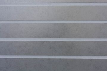 Gray ceramic tile with convex horizontal lines for wall and floor decoration. Concrete stone surface background.