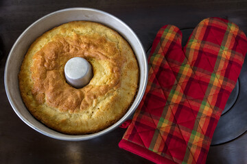 Bolo caseiro na forma e luva térmica vermelha