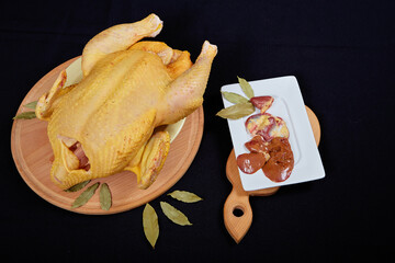 Raw chicken on black background. © Malsveta