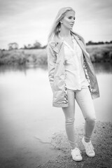 Young Woman Standing By A River Looking Away In Black And White