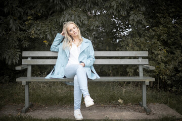 Young Woman Sitting On a Bench In A Park