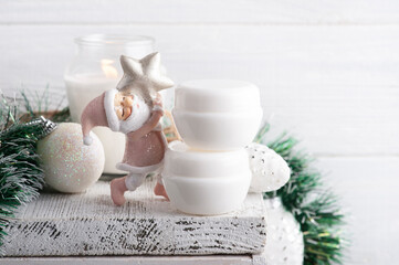 White jars in Christmas composition with lit candle