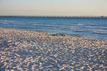 sunset at the sea in front of the blue water and white sand of the beach