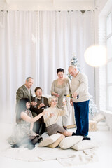 Family, happiness, generation, holidays and people concept. Happy smiling family, drinking champagne and clinking glasses, while celebrating christmas. Handsome father pours champagne