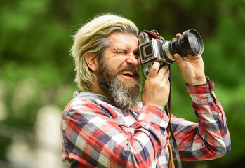 Man bearded hipster photographer hold vintage camera. Man with beard shooting photos. Photographer concept. Photographer amateur photographer nature background. Content creator. Masterpiece shot