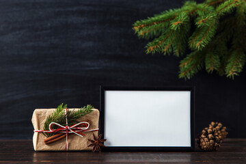 Christmas tree branches, gift and decoration on chalkboard background. The concept of a merry Christmas. Copy space.
