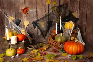 Foto op Canvas background texture of Halloween pumpkins with yellow leaves in a web and candles. photo zone in the style of the Halloween holiday © Svetlana
