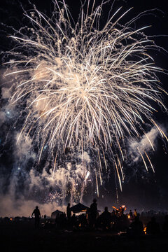 large fireworks display over a crowd of anonymous people