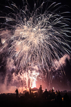 large fireworks display over a crowd of anonymous people