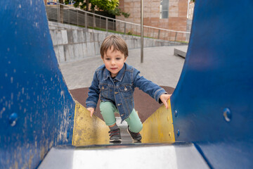 boy climbing a slide in a park