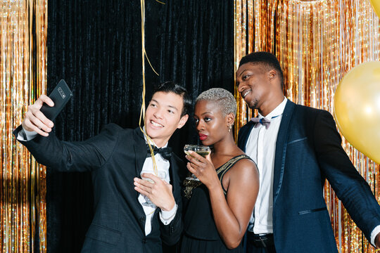Festive diverse friends celebrating and taking selfie