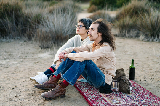 Adult couple with wine relaxing on beach
