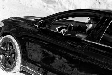 Attractive elegant serious man drives good car. Macho man in luxury auto. Selective focus. Black and white photo.