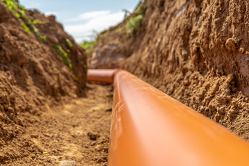 Plastic pipes in the ground during the construction of a building, bunner with copy space