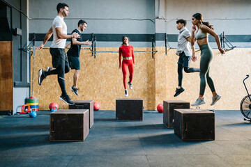 Group of athletes jumping on cubes during training