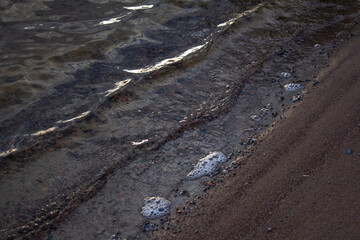 The sand is washed by water on which the sunset rays Shine