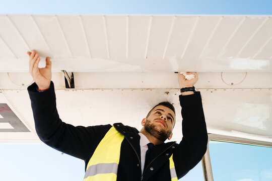 Male engineer examining light plane on airfield