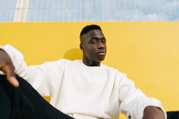 Modern black man sitting on playground