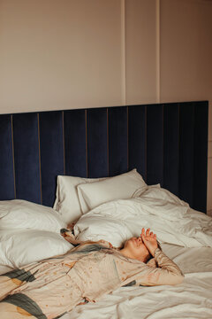 Tired woman laying on bed near laptop