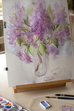 Watercolor violet flower bouquet on table easel
