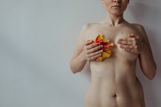 Real body type woman holding tulip near her breast
