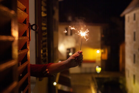 holiday mood, hand holding sparkler out of the window