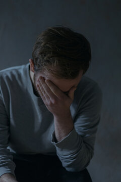 portraits of a guy in a depressed mood at home by a window in a dim light