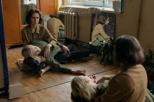 guy lies on his boyfriend's feet in the room