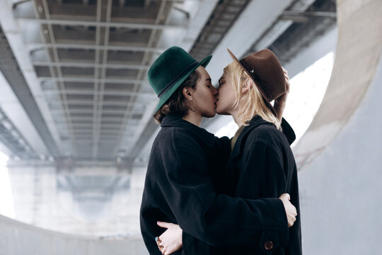 two guys kiss on the background of the bridge