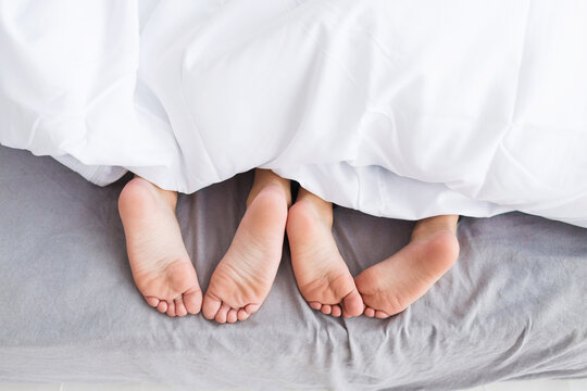 Children's feet peeking out from under the blanket