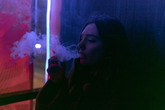 GIRL SMOKS CIGARETTE IN MIXED LIGHT COLOR