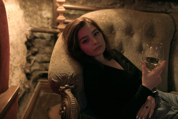 girl with a glass of wine in hand on the couch