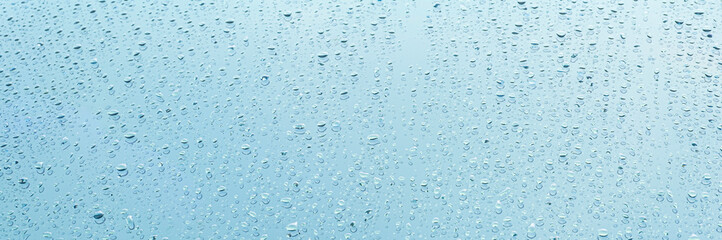 Raindrop water dew drop on glass wet white gray blue background.