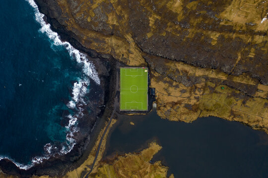 Bird eye view over a football field between ocean and a lake, Faroe islands